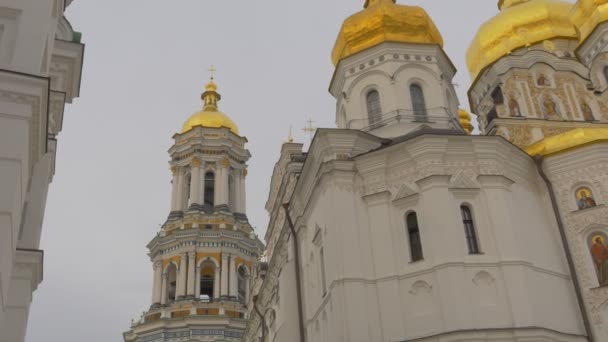 Glockenturm der Entschlafungskathedrale Weg zu einem Turm zwischen Mauern goldene Kuppeln weiße Wände heilige Annahme Kiev-pechersk lavra panorama ukraine bewölkter Tag — Stockvideo