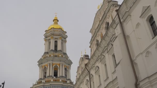 A közelben harangtorony Dormition Cathedral sárga és fehér falak, oszlopok Szent feltételezés Kiev-Pechersk Lavra panoráma Ukrajna felhős napon kereszt sír — Stock videók