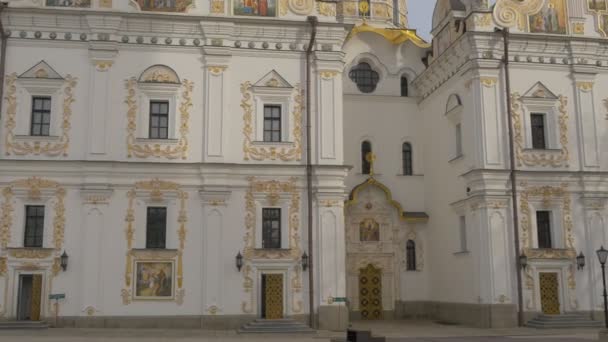 Parte del antiguo edificio cerca de la catedral de la Dormición decorada con elementos dorados Entrada principal Santa Dormición Kiev-Pechersk Lavra Patio Valla decorativa — Vídeo de stock