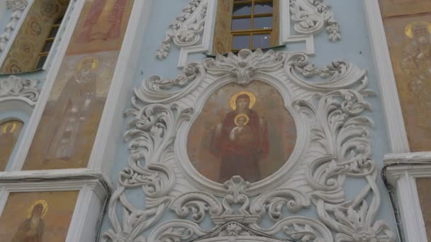 Laubsägearbeiten an einer Wand Eingang zu einer Entschlafungskathedrale Bilder von Heiligen mit goldenen Heiligenschein halbkreisförmige Fenster heilige Entschlafung kiev-pechersk lavra ukraine kiev — Stockvideo