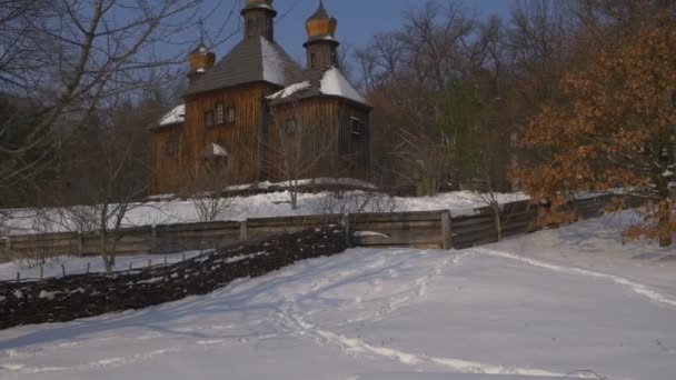 Tabell täckt med snö utomhus vinter kyrkan Heliga Michael ärkeängeln i Pirogovo Ukraina gamla trä kyrkliga Obsotele bygga soliga frostig dag — Stockvideo