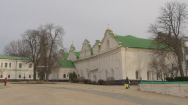 İnsanlar Dormition Katedrali yapraksız ağaçlar çalılar beyaz duvarlar Kilisesi yeşil çatılar kilise karmaşık Ukrayna ile varsayım binaların bir avlu kapısı