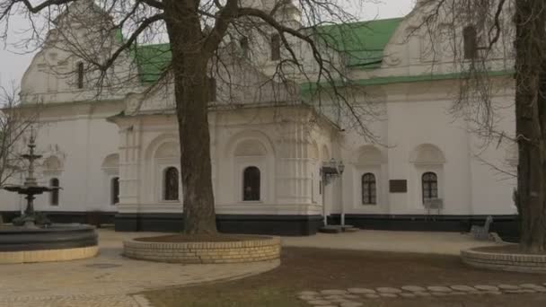 Walkers Silhouette gården i Dormition domkyrka fontän med ingen vatten kyrkan i antagandet byggnader med grönt tak kyrkan komplexa Ukraina — Stockvideo