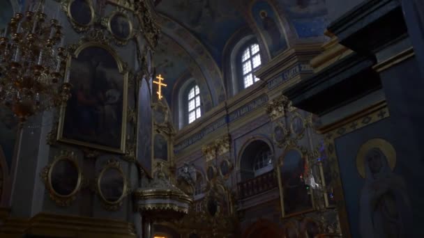 Siluety lidí v Uspenské katedrály vánoční svaté Dormition Pochaiv Lavra interiéru kostela vánoční osvětlení zdobené vánoční stromky Dark Hall — Stock video