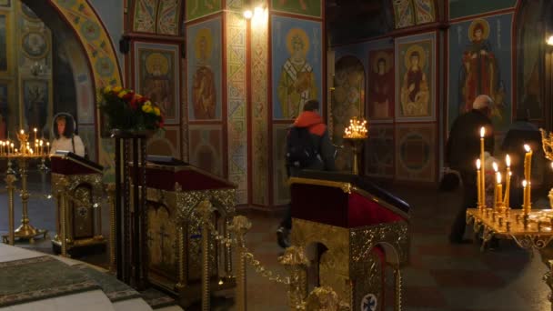 Personnes Saint Michael's Golden Top Homme Monastère Veille de Noël Kiev Les gens s'inclinent Croix eux-mêmes en priant dans la sombre salle de l'église Images Icônes Bougies — Video