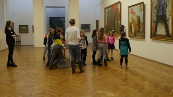 Kinder sind beim Ausflug ins nationale Kunstmuseum in Kiew Heiligabend ukrainische Kinder sitzen am Tisch Lehrer erzählt über die Gemälde — Stockvideo