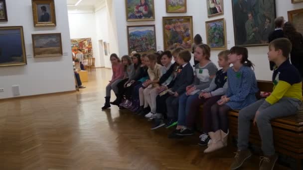 Kinder sitzen in der Schlange Ausflug National Art Museum Kiew Heiligabend ukraine weibliche Lehrerin erzählt von einem Bild Kinder hören nicht aufmerksam zu — Stockvideo