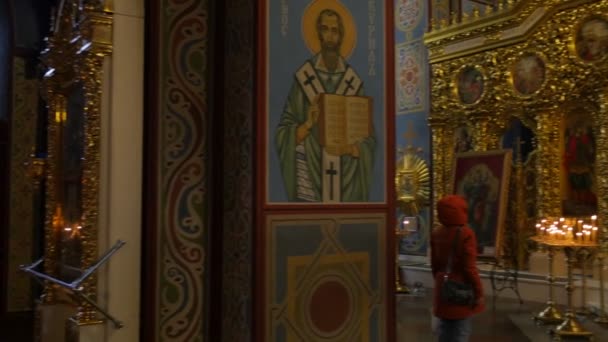 Femme au Monastère Masculin de Saint Michel Veille de Noël Kiev Femme est debout devant l'image Prier décor doré Image de Michael sous des bougies en verre — Video