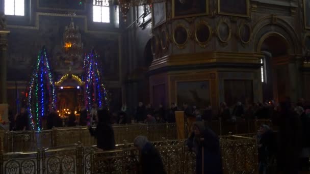 Persone al servizio Dormizione Cattedrale Natale decorato Firs adoratori stanno guardando Interno della Chiesa decorato Firs Monastero ortodosso Ucraina — Video Stock