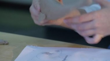 Çocuğun elleri olan heykel balık figürin kil heykel tablo küçük bir sarışın kız yerleştirilir Concentratedly heykel seramik Atölyesi'nde olduğunu