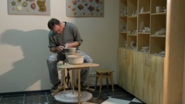 Erkek Potter bir tekerlek ile Spatula adam bir potu Çömlekçilik direksiyonda çalışma şekilleri bir kil kavanoz ya da Pot öğrenme bir çanak çömlek zanaat çanak çömlek Atölyesi kalıplama