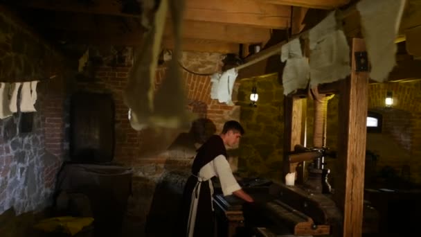 Řemeslník rotační tiskové zpracování papírenských technologií s prastaré řemeslo muzeum v Radomyšl chlap v temné místnosti folklorní kostým starověký nástroje — Stock video