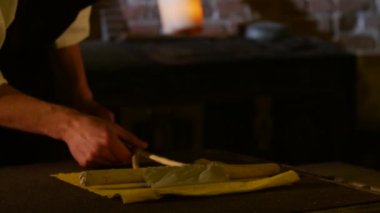 Adam bir ıslak kağıt Kağıt yapımı kale müze, ışık Age-Old teknoloji Radomişl kağıt verme işlemi adam folklor kostüm içinde yakın koymak