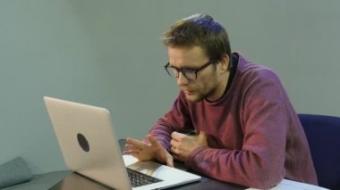Adam Talking zor ilgili sorunlar ile çalışan bir kupa Seroius Freelancer programcı metin yazarı Tasarımcısı muhasebeci elinde Skype Gesticulating üzerinde