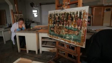 Kadın adam üç sanatçı onların iş simgeleri restorasyon Ortodoks görüntüleri tamir dükkanı restorasyon grubu, Kiev boyama Easels stüdyoda çalışıyor