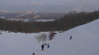 Eğlenceli bir atlı kızak var tarafından bir atlı kızak kış Hill yamaç sağ sahil nehir Dinyeper çocuklar çoğu çalışan Hill geliyor aşağı yukarı binmek için tepeye yürüme çocuklar
