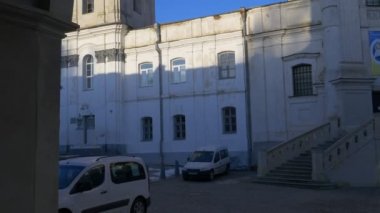 Giriş bir avlu Carmelites'sinin Manastırı Berdiçev park edilmiş arabalar merdiven kuleleri bir Barok tarzı Katolik Vintage antik yapı güneşli gün Ukrayna