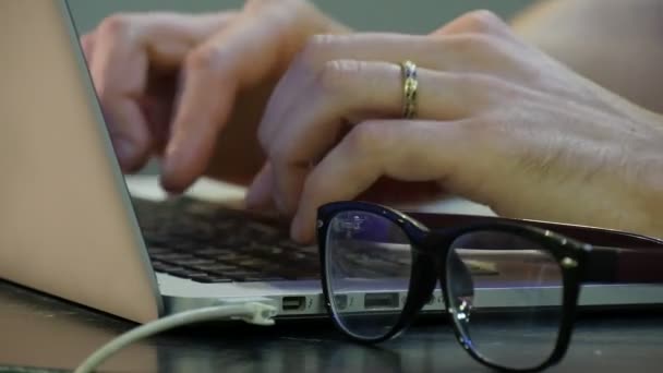 Man 's Hands Are Typing Working With Laptop Chatting Glasses Are Placed on a Foreground Freelancer Programmer Copywriter Designer Accountant is Working Hard — Stok Video