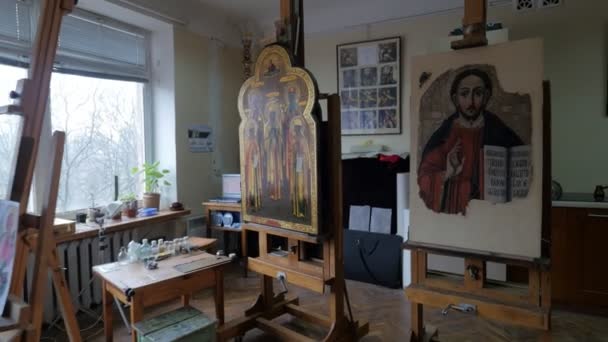 Hombre en gafas lupa pintura restauración icono iconos ortodoxos taller de reparación restauración Grupo está trabajando en el estudio en Kiev pinturas caballetes cepillos — Vídeo de stock