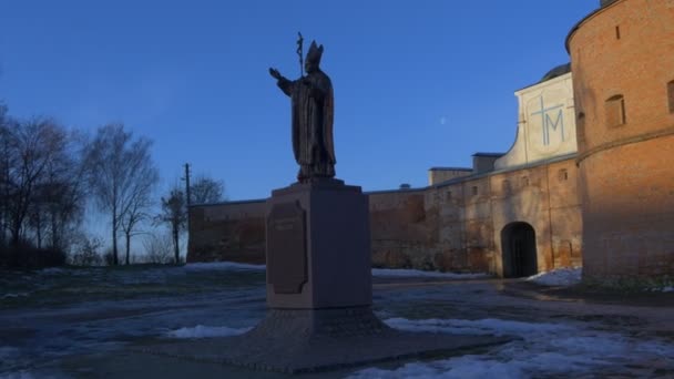 Mädchen am Denkmal für einen Papst barfuß Karmelitenkloster in Berdichev katholischen Schutzmauern der Kirchtürme in einem barocken Stil sonnigen Tag Winter — Stockvideo