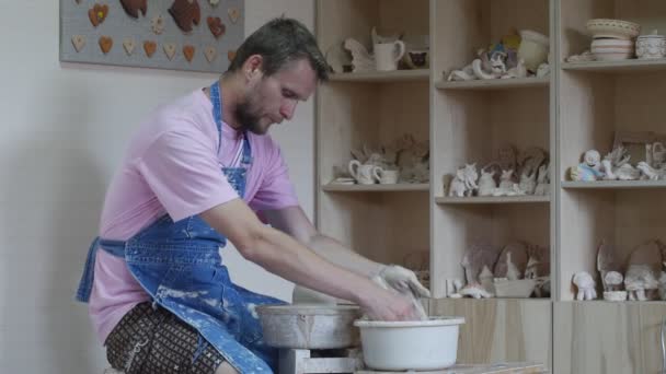 Student Potter sta facendo ruotare una ruota che fa un vaso che lavora su una ruota di ceramica che impara un laboratorio di ceramica artigianale lava le mani in acqua e stampaggio — Video Stock