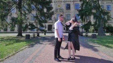 Diploma Mutlu Genç Adam ve Kadın Alley Sunny Day Yürüyüş Gülümseyerek El Ele Tutuşan Manto üniversitekadın Dışında Yürüyüş Graduands Çift
