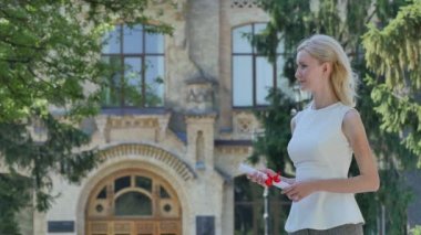 Rektör, Güneşli Yaz Günü Üniversite Nin Dışındaki Sokakta Mezuniyet Töreni'nde Gülen Manto'daki Mutlu Graduand Genç Kadına Diploma Veriyor