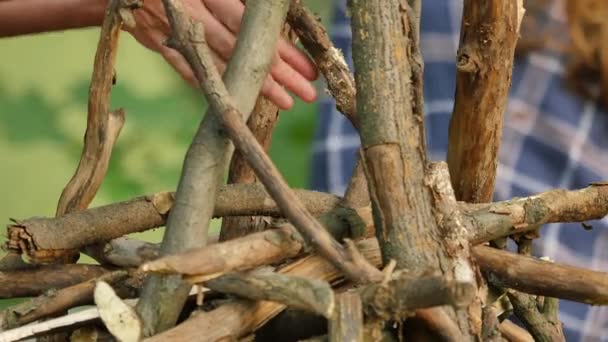 La mano de la mujer rocía algo en la leña El hombre está estableciendo un trozo de madera en el festival pagano de Ivan Kupala Fire Kindling People celebra en verano — Vídeo de stock