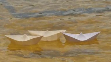 Üç beyaz kağıt gemi tarafından nehir çocukça eğlence oyun rüya yüzey yalnızlık yalnızlık Flotilla kağıt gemiler kağıt geminin güneşli bir nehir üzerinde yüzen