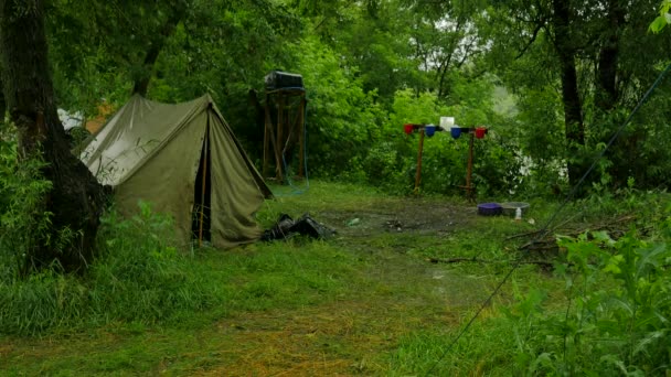 Man Walking av turist bas personer i ett tält läger i hälla regn lummiga gröna träden i skogen regniga dagen på floden regnet är tvätta bort alla spår — Stockvideo