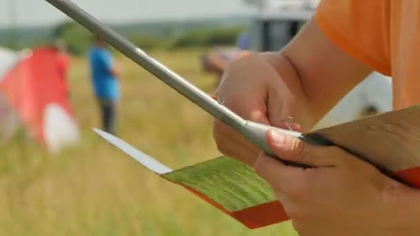 Junge überprüft ein Flugzeug Sport Wettbewerb im Freien Menschen Minibus auf Hintergrund konotop Ukraine Vorbereitung für Flugzeug Start Modelle Montage — Stockvideo