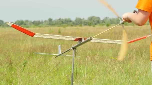 Preparación de un avión con motor de goma Lanzamiento de personas en la competencia de deportes modelo de aviones en Konotop Ucrania adolescente está lanzando un avión — Vídeos de Stock