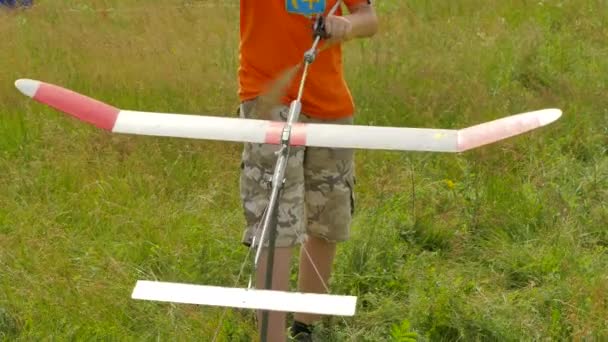 Boy está lanzando el modelo de avión de goma Modelo de avión Competencia deportiva al aire libre Ucrania Preparación para el lanzamiento de aviones Estimación de inicio y vuelo — Vídeos de Stock