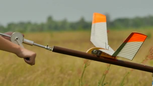 Preparación de un modelo de avión para el niño de lanzamiento y el instructor de establecer un modelo con el motor de goma de la gente en el avión Modelo de competición deportiva al aire libre — Vídeo de stock