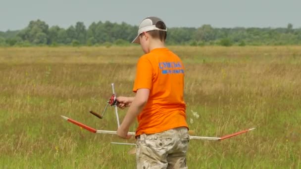 Boy Ajuste de su avión Modelo de avión Competencia al aire libre Konotop Ucrania Preparación para el lanzamiento de aviones Modelos Montaje Estimación del vuelo — Vídeos de Stock