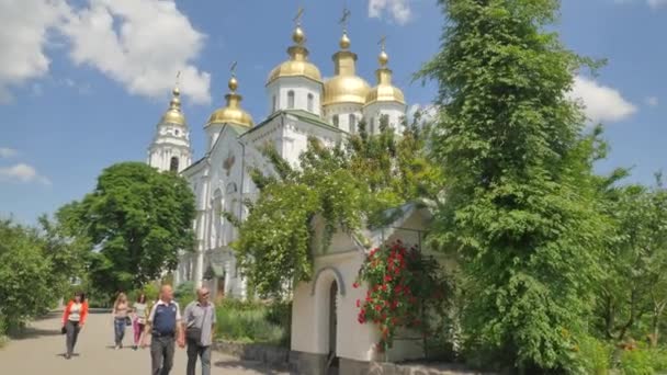 Svatý Kříž katedrála Poltava City Green střechou kostela slunečný den nádvoří chodníky dláždit květinové záhony a stromy a trávníky bílé stěny a Windows letní — Stock video