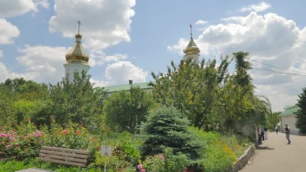 Φυτά στο έδαφος της Ιερά Μονή Σταυρού Πολτάβα πόλη μονοπάτια αυλή ανοίγοντας παρτέρια δέντρα το γκαζόν και λευκό τοίχοι και παράθυρα καλοκαίρι — Αρχείο Βίντεο