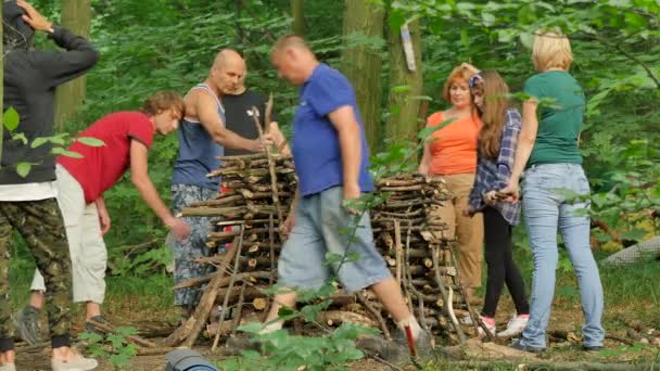 Lidé přinášejí dříví nastavit oheň pohanský Festival Ivana Kupala Kiev mužů a žen se bude slavit v lese jsou zelené stromy kolem letního dne — Stock video