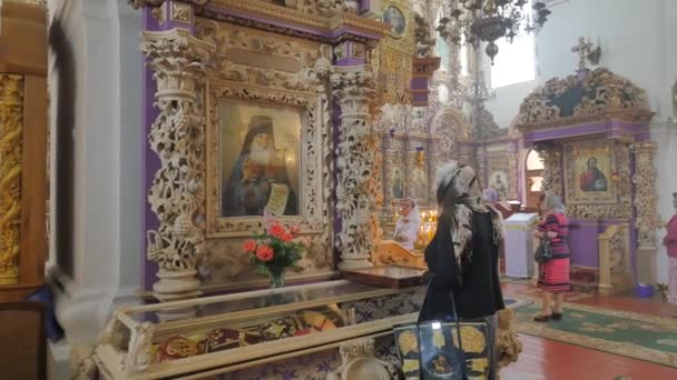 Mensen iconen interieur van de Heilige Kruis kathedraal Trinity Day aanbidders religieuze attributen brander van potten architectonisch monument Poltava stad Oekraïne — Stockvideo