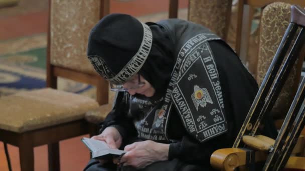 Mensen geestelijkheid bij Trinity Day service zeven koepel kathedraal in Poltava Senior Nun in zwart kledingstuk benaderingen voorbeeld Crossing zichzelf kaarsen branden — Stockvideo
