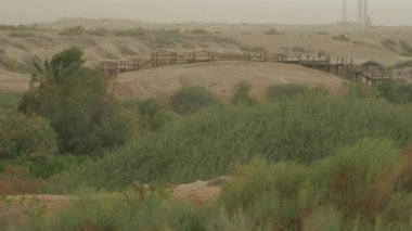 Manzara Bulutlu Windy Day Ahşap Köprü Nehir Step Field Hills Kumlu Zemin Yeşil Çim ve Ağaçlar Rüzgar Doğa Açık Sallanan vardır