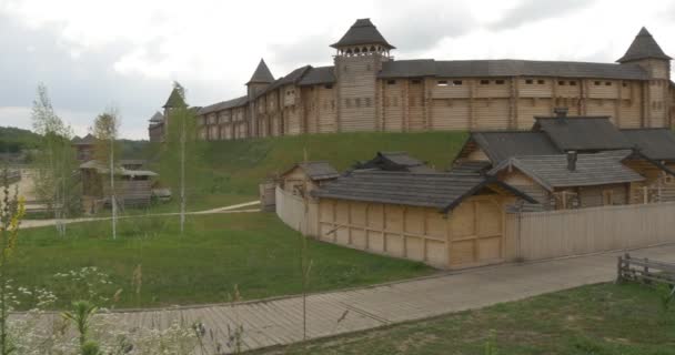 Pevnost na kopci, zdi pevnosti, šedé mraky, silnice vedle zdi, strážní věže, cesta z klády, Dřevěná cesta, Dvorský dvůr, koňská pastvina — Stock video