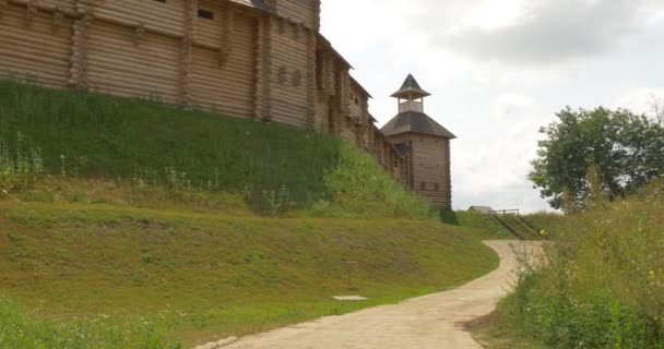 Fästning kulle, fästning väggar, Woden väggar, timmerväggar, vakttorn, spåra rätt, grå moln, sommar, soligt, grönt gräs, Kievan Russ, 11-talet — Stockvideo