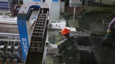 Çalışan makine, bileme makinesi, üç işçi, turuncu Emanet kask, erkeklerde cam fabrika makinelerde cam levha işleme