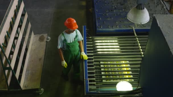 Работник берет стеклянные листы, контролирует качество обрабатываемого стекла, готовую обработку, завод по обработке листового стекла на станках — стоковое видео