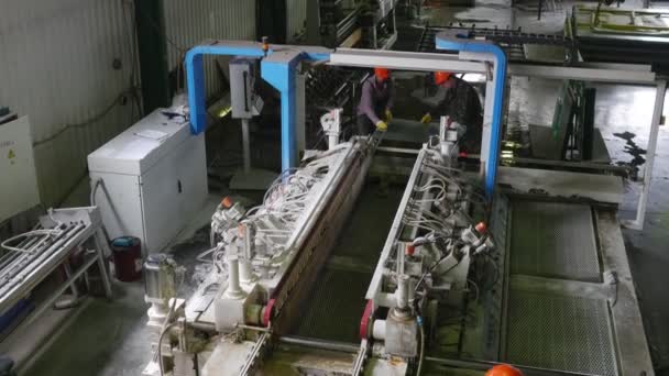 Drie werknemers, transmissie van een glas in slijp machine, fabriek voor de verwerking van plaat glas op de machines met programmabesturing — Stockvideo