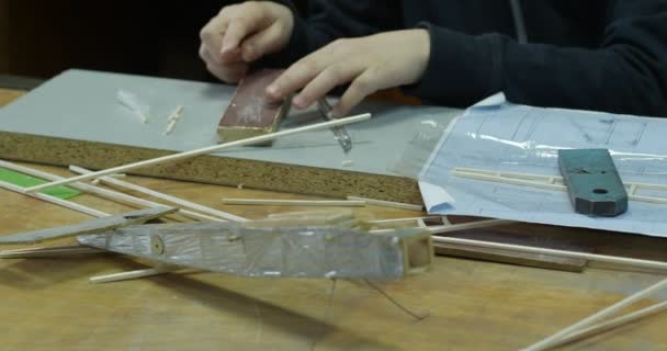 Billet of Plane is on The Table, Modèle en bois, Mains de garçon, Garçon broie les détails, Laboratoire de modélisation Avia pour enfants — Video