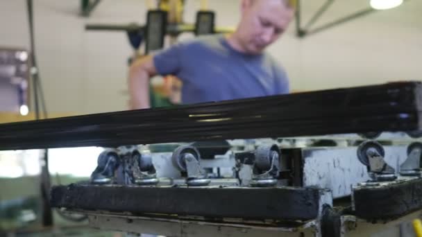 Los hombres trabajadores trabajador está haciendo hermético sellado de borde de vidrio esmaltado con sellador Mastic Worker pone un negro Mastic por espátula taller — Vídeos de Stock