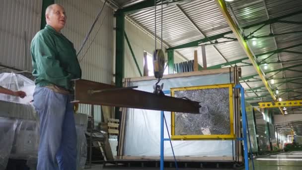 Lavoratore in abiti da lavoro è in piedi a testato vetro Battering Ram è appeso sulla corda Man sta guardando la lastra di vetro — Video Stock