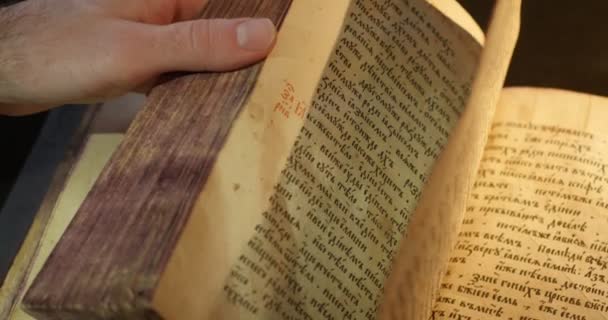 Man 's Hand on Old Book Paterik of Kiev-Pecherska Lavra Gravuras de Escrita Eslavo-Velha Imagens Episódios da Vida dos Santos Monges Virando Páginas — Vídeo de Stock